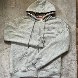 Burberry zip hoodie - Säljer denna burberry hoodien i ny skick då den inte är rätt storlek. Storlek L och har endast använts 2-3 gånger. 