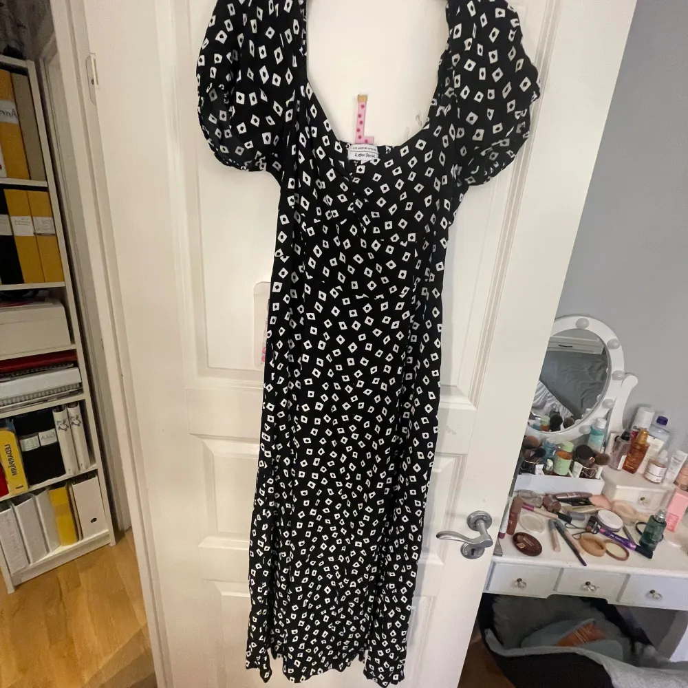 Snygg långklänning från & Other Stories med ett unikt svart och vitt mönster. Klänningen har korta puffärmar och en smickrande passform. Perfekt för en stilfull look.. Mekot.