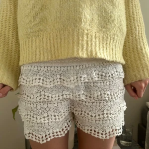 Vita spets shorts - Säljer ett par vita shorts med vacker spetsdesign. De har flera lager av spetsdetaljer som ger en romantisk och somrig känsla. Perfekta för varma dagar! Supertrendiga!!