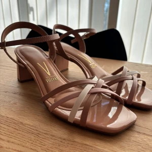 Beige sandaler med klack - Snygga beige sandaler från Vizzano med en elegant klack och remmar i olika nyanser av beige och vit. De har en fyrkantig tå och justerbar ankelrem för perfekt passform. Perfekta för bal eller festligt tillfälle. Vadderade så mycket bekväma att gå i! Använda vid två tillfällen💕