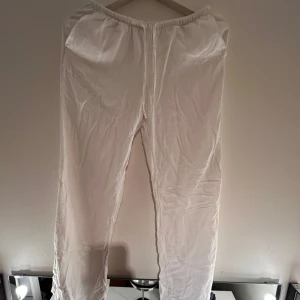 Vita linnebyxor från H&M - Säljer ett par vita linnebyxor från H&M med elastisk midja. Perfekta för en avslappnad stil. Byxorna är tillverkade i ett lätt och bekvämt material. Kontakta mig om det är något. Köparen står för köpet💞