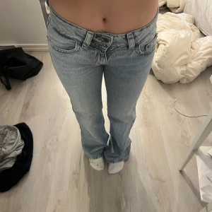 Ljusblå jeans med bootcut - Snygga ljusblå jeans med bootcut-stil och klassisk femficksdesign. De har en lågmidjad passform och är perfekta för en avslappnad look. Jeansen har en dragkedja och knapp framtill. Använda två gånger . Pris kan diskutera vid snabbt köp