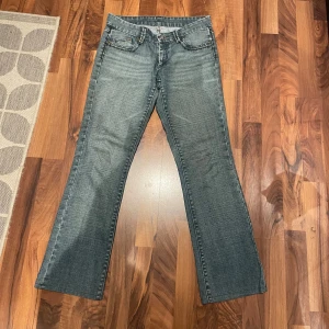 Grå bootcut jeans Lowrise  - Snygga grå bootcut jeans med klassisk femficksdesign. Perfekta för en avslappnad stil med en touch av retro. De har en bekväm passform och är tillverkade i ett slitstarkt material.