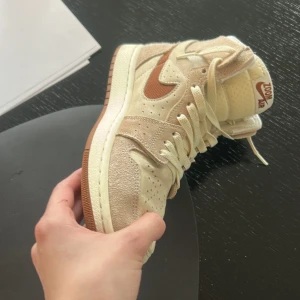 Nike Air Jordan 1 Zoom Air i beige och brunt - Snygga Nike Air Jordan 1 Zoom Air sneakers i en stilren kombination av beige och brunt. Skorna har en rund tå och är tillverkade i mocka och syntetmaterial. Perfekta för dig som vill ha en klassisk och bekväm sneaker med snörning.              Dom kommer med den originella boxen och dom är gjorda för att vara lite mer åt det bekväma hållet om det hjälper. Kontackta mig vid minsta fråga 