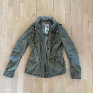 Grön vår jacka tjej storlek S - Fin grön vår jacka med dragkedja och knappar. Jackan har flera fickor. Säljer den då den ej kommer till användning. Passar mig som är 164. 