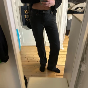 Svarta jeans med rak passform - Snygga svarta jeans med rak passform och klassisk design. De har en knapp och dragkedja framtill samt fem fickor och de är stretchiga. Perfekta för en stilren look.