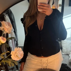 Svart kofta med volanger - Säljer en jättefin svart kofta med volanger framtill. Koftan har långa ärmar och en jättefin desgin. Den är gammal från Zara och säljs inte längre. Jättefint sick! Passar S storleksmässigt 🩷❤️😍