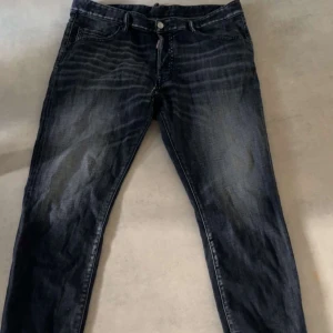 Svarta jeans från DSQUARED2 - Snygga svarta jeans från DSQUARED2 med en cool tvättad look. Det är en litet hål ni ser på bilder därav priset, priset kan diskuteras 