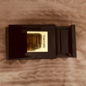 Tom Ford Tobacco Vanille Eau de Parfum 100 ml - Lyxig parfym från Tom Ford i doften Tobacco Vanille. Flaskan är svart med en guldig etikett och rymmer 100 ml Eau de Parfum. En elegant och kraftfull doft med inslag av tobak och vanilj.