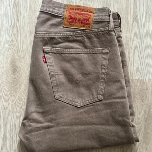 Beige Levis 501 jeans - Säljer ett par klassiska Levis 501 jeans i beige. Strl 33/32, snygga nu inför sommaren. Inte använd mer än 10 ggr, mestadels bara legat ihopvikt i garderoben. Köpt för 1149kr. 