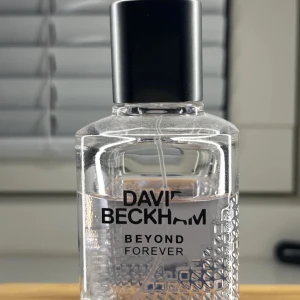 David Beckham Beyond Forever herrparfym - Fräsch och modern herrparfym från David Beckham, Beyond Forever. Flaskan är transparent med ett stilrent rutmönster och svart lock. Doften passar dig som gillar eleganta och sportiga inslag.