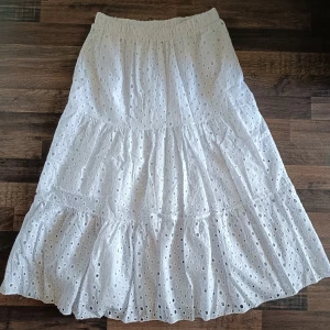 Vit kjol från ESCAPE - Superfin vit kjol från ESCAPE med broderie mönster. Kjolen har resår i midjan och flera volanger som ger en luftig och somrig känsla. Perfekt till varma dagar och enkel att styla med en enkel topp. Superfin men kommer tyvärr inte till användning. Köpt för 499kr men jag säljer den för 300 kr💕