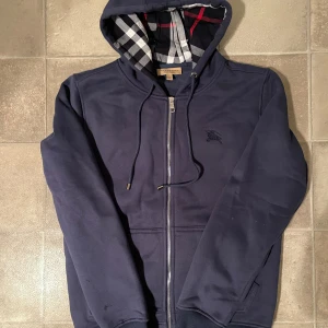 Burberry Hoodie - Tja, säljer min Marin blåa Burberry hoodie då den inte kommer till användning längre. Tröjan är i storlek M och är i bra skick. Kan tänka mig gå ner i pris vid snabb affär👍