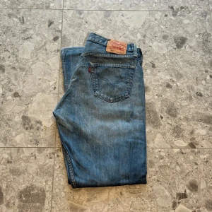 Levi's 501 blå jeans - Klassiska blå Levi's 501 jeans med raka ben. Storlek W34, L36. Väldigt snygga jeans enligt mig och är i bra skick. Nypriset ligger på cirka 1400 så ett väldigt bra pris.