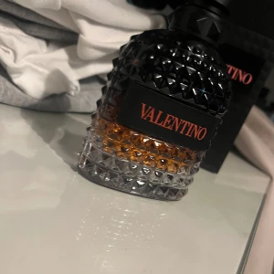 Valentino Uomo Born In Roma Coral Fantasy EdT - Exklusiv herrparfym från Valentino, Born In Roma Coral Fantasy. Flaskan är mönstrad i glas med svart och orange detaljer, och rymmer 100 ml. Doften är modern och elegant, perfekt för dig som vill sticka ut.