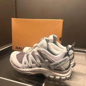Salomon XA Pro 3D sneakers i vitt och grått - Säljer ett par Salomon XA Pro 3D sneakers i vitt och grått med svarta detaljer. Skorna är tydligen en av världens bästa springskor, sjukt sköna, men följer inte mig helt i smaken, provat på en gång, Aldrig anvädna!
