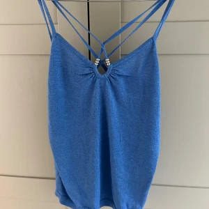 Blå topp med pärldetalj - Säljer min såå snygga blå-glittriga topp som är perfekt nu till sommaren💕💕köpt för några år sen så går ej att få tag på!! Den har inga defekter - OBS: tryck INTE på köp nu utan att jag har bekräftat att du kan köpa plagget 