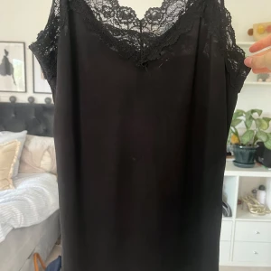 Svart spetslinne från Object - Säljer ett svart spetslinne från Object med vacker spets upptill och smala axelband. Axelbanden går att spänna åt och linnet sitter hyfsat tight. INGA DEFEKTER!!🖤🖤