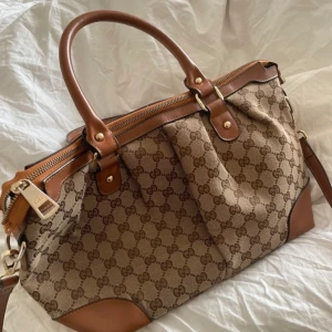 Vintage Gucci väska  - Vintage gucci väska i toppen skick! Lite trasig i dragkedjan men fungerar fortfarande som vanligt. Köpt vintage, riktigt snygg och unik väska!!💕
