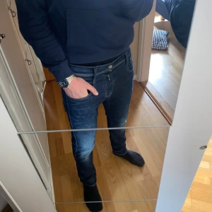 Replay Anbass Hyperflex jeans i mörkblå denim - Säljer ett par Replay Anbass Hyperflex jeans i mörkblå tvätt med snygga slitningar. 