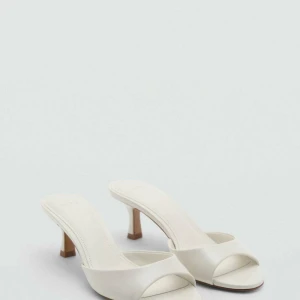 Vita klackade sandaler från MNG - Stilrena vita sandaler från Mango med öppen tå och låg klack. Skorna har en minimalistisk design med bred rem över foten och är tillverkade i syntetmaterial. Klackhöjd: 4 cm i storlek 37. Använda 1 gång och är så bekväma och sköna att gå i🩷🩷