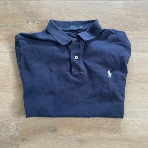 Ralph lauren pike - Säljer denna riktigt snygga Ralph lauren pike, den är i mycket bra skick, storlek M men den är ganska liten i storleken så jag skulle påstå att den passar mer som S passar bra på dig som är 170-175, tyvärr är tvättlappen avklippt, hör gärna av dig om du har frågor!