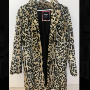 Leopardmönstrad pälsjacka Pepe Jeans - Säljer en sjukt snygg pälsjacka från Pepe Jeans i leopardmönster. Jackan är beige med svarta och bruna detaljer, har krage och är helfodrad. Perfekt statement-plagg för dig som vill sticka ut och hålla dig varm under kalla dagar.