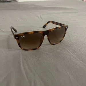 Bruna Ray-Ban Wayfarer solglasögon - Snygga Ray-Ban Wayfarer solglasögon med brunmelerat mönster och fyrkantig form. Glasen är mörktonade och bågarna är i plast med klassisk logga på sidan. Perfekta för att lyfta din stil med en tidlös vibe. Pris kan diskuteras vid snabb affär 
