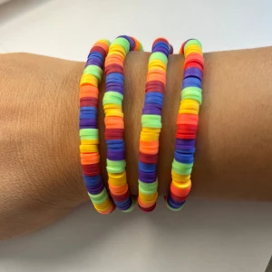 Clay beads armband i PRIDE färger  - 🏳️‍🌈🏳️‍🌈PRIDE MÅNAD 🏳️‍🌈🏳️‍🌈Coola armband med platta pärlor i regnbågens alla färger. Armbanden är elastiska och består av tunna, runda skivor i lila, blått, grönt, gult, orange och rött. 1 st för 75 kr 3 för 150 kr 