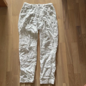 Vita linnebyxor från Zara, stl S - Snygga vita linnebyxor från Zara i storlek S. Byxorna har avslappnad passform, resår baktill i midjan och fickor på sidorna. Perfekta för varma dagar och ger en fräsch och clean look.