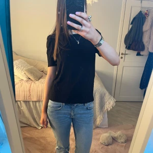 Svart puffärm t-shirt  - Svart t-shirt med puffärmar och rund halsringning. Modellen är rak och har en enkel, stilren look. Från Indiska i storlek XS. Inga defekter och använd fåtal gånger.