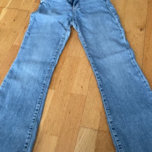 Ljusblå bootcut jeans med rå kant - Säljer ett par ljusblå jeans med bootcut-modell, använt flera gånger därför de är trasiga där nere 