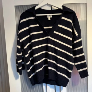 Svartvitrandig stickad tröja med v-ringning - Mysig stickad tröja från H&M i svart med vita ränder. Tröjan har en djup v-ringning och en avslappnad passform. Skriv privat för fler bilder 🩷