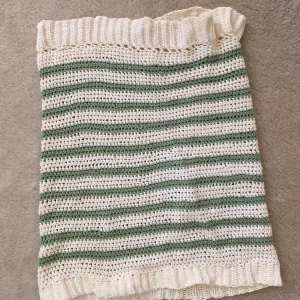 Virkad randig kjol i grönt och vitt - Säljer en handvirkad (av mig) kjol med gröna och vita ränder. Kjolen har en rak passform och elastisk midja med volangkant upptill och nertill. Funkar också som en Bandeau topp. På baksidan ser man att den är egen gjord och lite osymmetrisk. 😄
