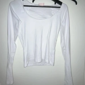 Vit långärmad topp från Nelly - Säljer en enkel och stilren vit långärmad topp från Nelly. Modellen har rund halsringning och är figurnära i passformen. Perfekt att matcha med jeans eller kjol för en clean look.