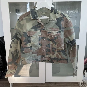 Kamouflage jeansjacka 💚🖤 - Köptes på Sellpy i ”Mycket bra” skick och har inga tecken på användning, jag har endast testat och tvättat den! Har bara varit i garderoben och aldrig kommit till användning. Strlk M men är lite kort i armarna + liten i storleken. FÖRST TILL KVARN!🖤💚(BUNDLERABATT VID KÖP AV FLER ARTIKLAR, KIKA MIN PROFIL!)