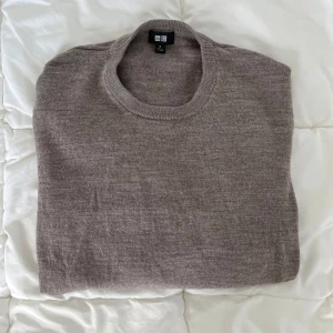Uniqlo ulltröja - Säljer nu min ulltröja från Uniqlo, i 100 % ull. Färgen är beige och storleken är M. Observera att det finns ett litet hål på höger ärm (syns på sista bilden) – det borde gå att laga själv eller lämna in till en skräddare.  Hör gärna av dig vid intresse!