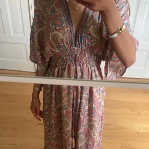 Mönstrad långklänning  - Säljer en bohemisk långklänning i rosa, blått och beige, köpt på en marknad. 