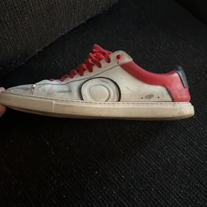 Oliver Cabell 42,43 - Snygga sneakers i svart och rött med vita detaljer. Skorna har en klassisk rund tå och är utrustade med röda snören. Perfekta för en stilren look. Endast små skador med är enkel fixade med hjälp av t.ex skolim Nypris 2600 (inkl tull) Priset ej hugget i sten så buda på🙂