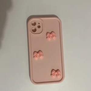 Iphone 11 skal - Ljus rosa iphone 11 skal med rosetter på. Helt nytt och oanvänt då det var fel storlek!💗