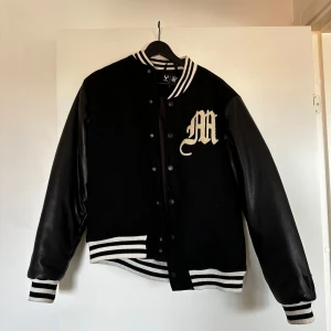 Collagejacka - Snygg svart collagejacka med vita detaljer och motiv på baksidan. Snygg till ett par blå jeans eller liknande! 