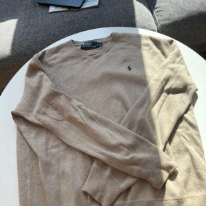 Beige tröja från Ralph Lauren - Riktigt snygg och stilig tröja från Ralph Lauren. Bra skick. Hade själv haft kvar den men den är för stor för mig.     Storlek M