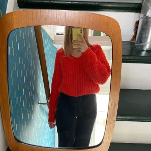 Orange stickad tröja med v-ringning - Säljer en snygg orange stickad tröja med v-ringning. Tröjan är croppad och har långa ärmar. Hela tröjan är lössittande och lite nopprig. Säljer för att den inte är min stil längre. Vid frågor hör av er. 