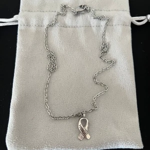  Rosa bandet halsband - Rosa bandet halsband vi donerar 10% per såld rosabandet halsband till bröstcancer fonden. Kjedjan är rostfri och berlocken är också rostfri. Och kjedjan är ca. 47cm.
