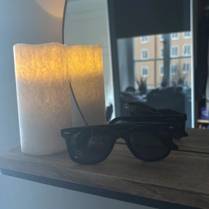 Svarta solglasögon från Ray-Ban - Snygga svarta solglasögon från Ray-Ban med klassisk design. Perfekta för soliga dagar och ger en cool look. De har en robust ram och mörka linser som skyddar mot solen.