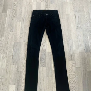 Svarta jeans från Nudie Jeans - Snygga svarta jeans från Nudie Jeans i modellen Tight Long John. Tillverkade av 98% ekologisk bomull och 2% elastan för en bekväm passform.