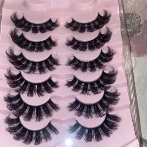 Säljer ett set med dramatiska svarta lösögonfransar. Perfekta för att ge en fyllig och intensiv look. Fransarna är täta och har en böjd form för att ge extra volym och längd. Kommer i en praktisk förpackning med flera par.