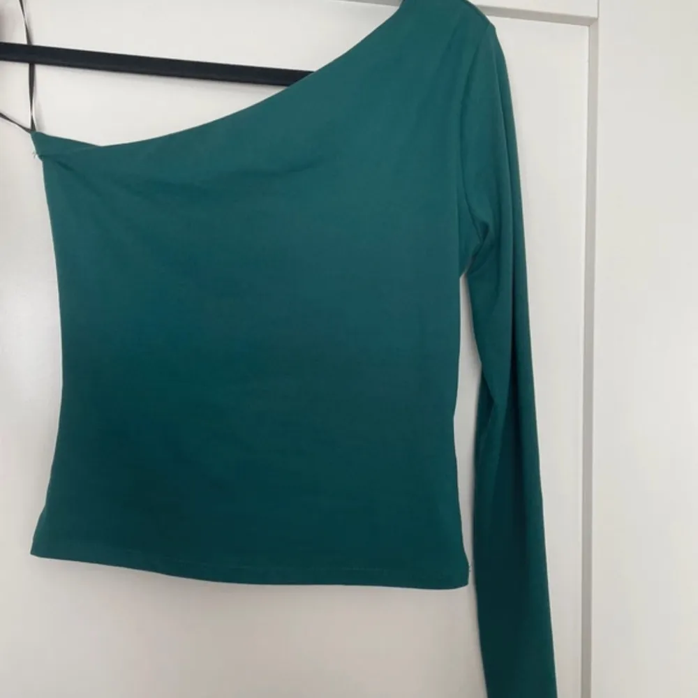 Grön one shoulder-topp från H&M i strl XS. Använd en gång.. Yläosat.