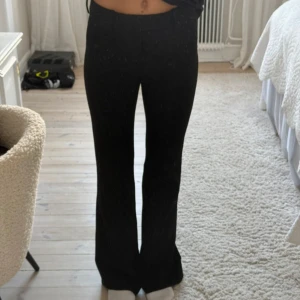 Svarta kostymbyxor med bootcut - Snygga svarta kostymbyxor med bootcut passform och hög midja. Byxorna har klassisk design med dragkedja och knapp framtill. Perfekta för en stilren look.