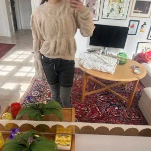 Beige stickad tröja med mönster - Säljer en beige stickad tröja med diskret mönster och lång ärm. Tröjan har en rund halsringning och är mjuk och skön, perfekt för kyligare dagar.